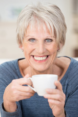 lächelnde ältere frau genießt eine tasse kaffee