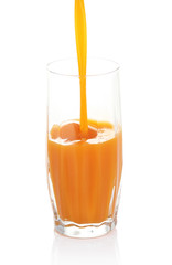 Juice pouring into glass isolated on white