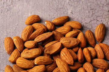 Almonds on color wooden background