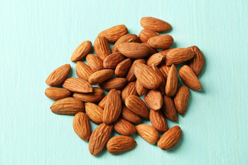 Almonds on color wooden background