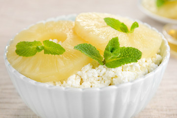 Bowl of tasty cottage cheese with pineapple, close up