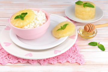 Bowl of tasty cottage cheese with pineapple on wooden table