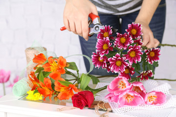 Female hands composing beautiful bouquet, close-up. Florist at
