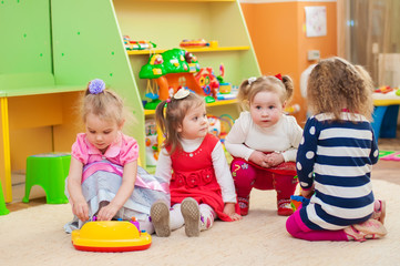 Little girls playing with toys in the playroom