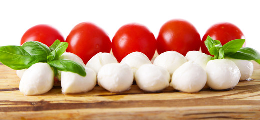 Tasty mozzarella cheese balls with basil and red tomatoes,