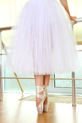 Ballerina legs in pointes in dancing hall © Africa Studio