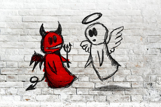 Angel and devil fighting; doodle drawing on white brick wall