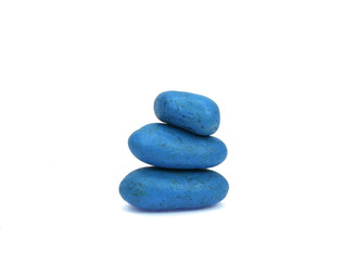 Stack of colored pebble stones on white background