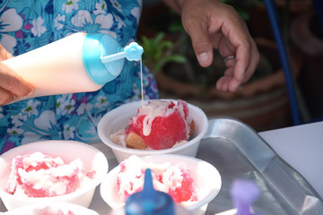 Flavouring a sweetened condensed milk snow cone shaved ice in a 