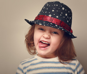 Happy grimacing kid girl in fashion hat. Closeup vintage