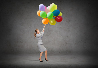 businesswoman pulling down bunch of balloons