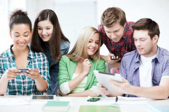 students looking at smartphones and tablet pc