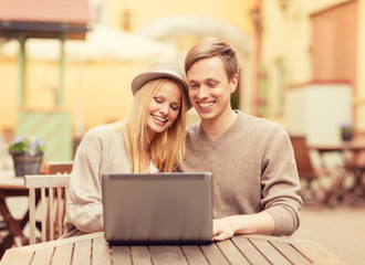 couple with laptop in cafe