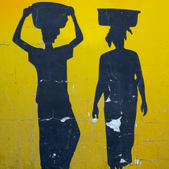 Silhouettes of African women painted on old wall