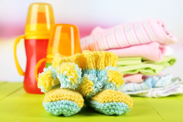 Composition with crocheted booties for baby,clothes, bottles