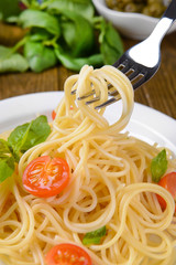 Delicious spaghetti with tomatoes on plate on table close-up