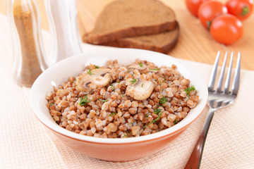 Boiled buckwheat in bowl on table close-up