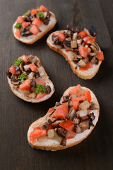 Delicious bruschetta with mushrooms on table close-up