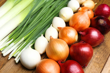 Different raw onion on wooden background