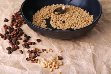 Cedar pine nuts on pan, on wooden table