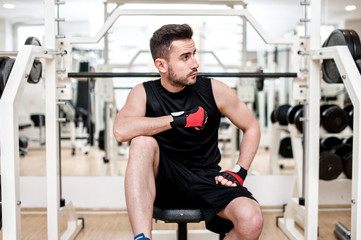 Man working out at gym, resting at  bench press