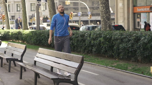 Jogger resting by bench in the city, super slow motion