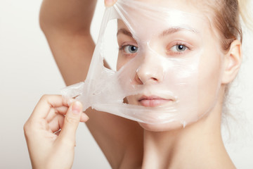 Girl woman in facial peel off mask. Skin care.