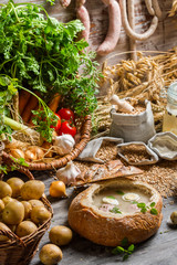 Homemade sour soup in bread with marjoram