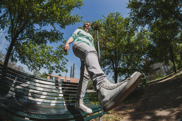 Fisheye shot of short hair girl standing on a bench