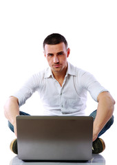Confident man using laptop on the floor over white background