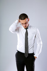 Portrait of a pensive businessman in glasses on gray background