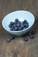 blueberries in a bowl on a wooden table