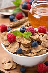 cereal flakes with berries, honey, milk for breakfast, closeup