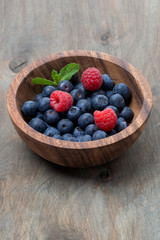 wooden bowl with blueberries and raspberries