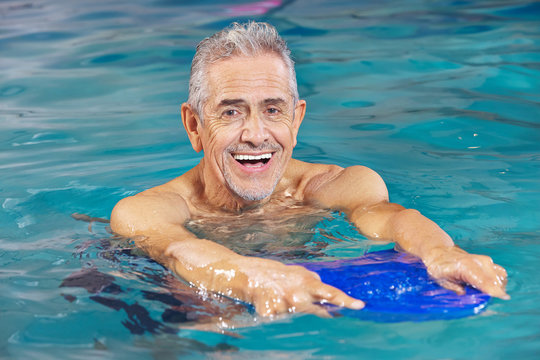 Senior man with kickboard in swimming pool