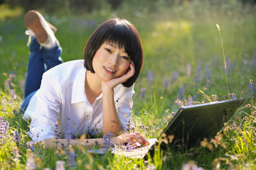 Beautiful asian student using laptop outdoor
