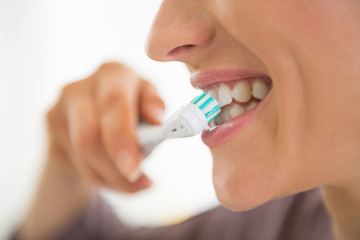 Closeup on young woman brushing teeth - obrazy, fototapety, plakaty