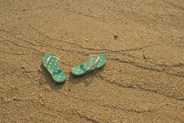 Fototapeta na wymiar Colorful flip flops on white sand beach in vintage style
