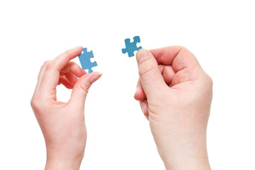 male and female hands with little puzzle pieces