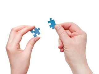 male and female hands with little puzzle pieces