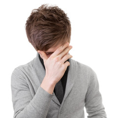 Sad young man covered his face with his hand. Isolation on white