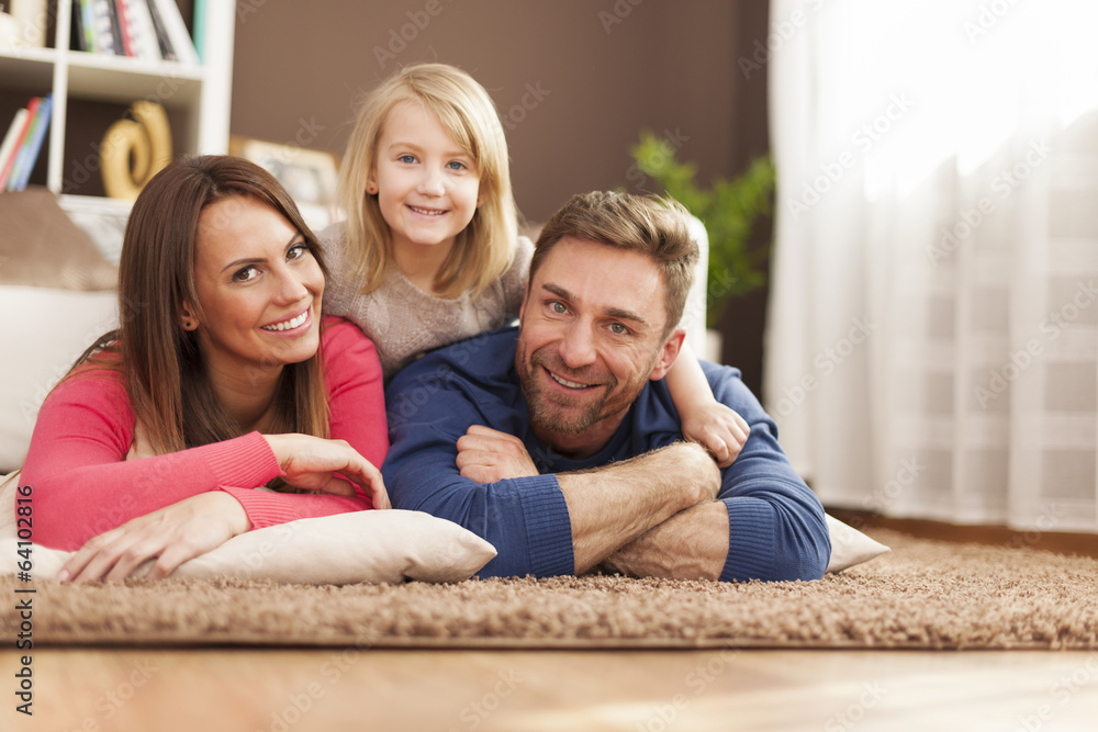 Wall mural Portrait of loving family on carpet