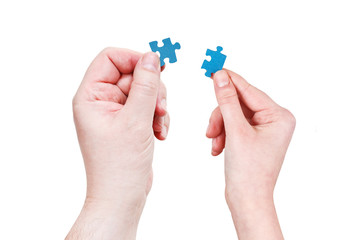 male and female hands with little puzzle pieces