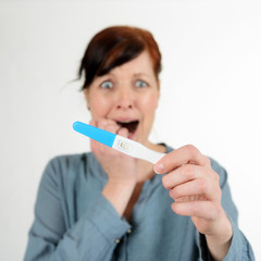 Schockierte Frau mit Schwangerschaftstest
