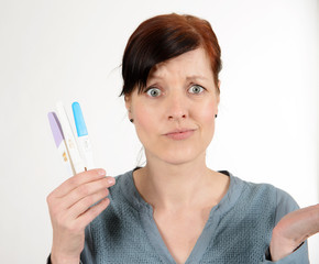 Ratlose Frau mit Schwangerschaftstests