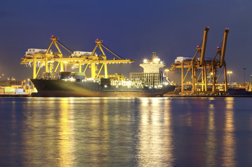 Obraz premium Gantry crane loading and unloading cargo container from cargo ship at port to show global international logistics and transportation by cargo ship and cargo container, Logistic import export concept.