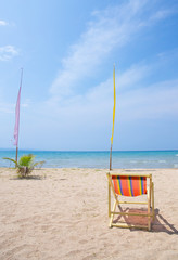 Beach chairs on the white sand beach with cloudy blue sky