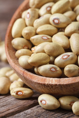 Raw pale yellow kidney beans macro in a spoon vertical
