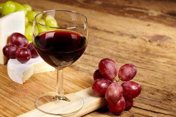 A red glass of wine and cheese