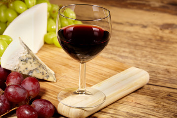 A red glass of wine and cheese